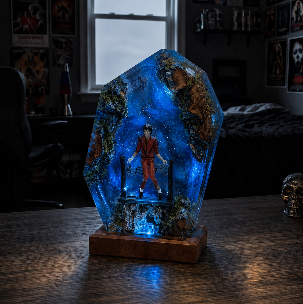 Decorative glass piece with a figure inside, illuminated by blue light on a wooden surface.
