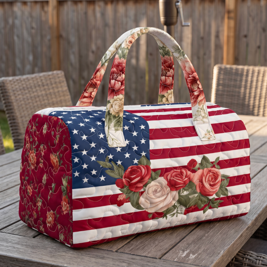 Quilted bag with American flag design and floral patterns on a wooden table outdoors.